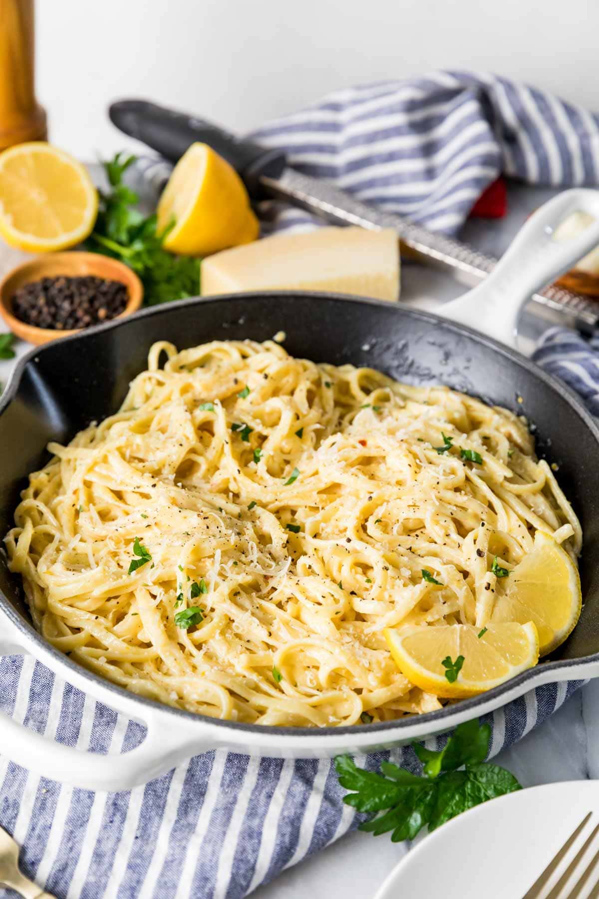 Close-up view of a skillet of linguine tossed in a lemon cream sauce.