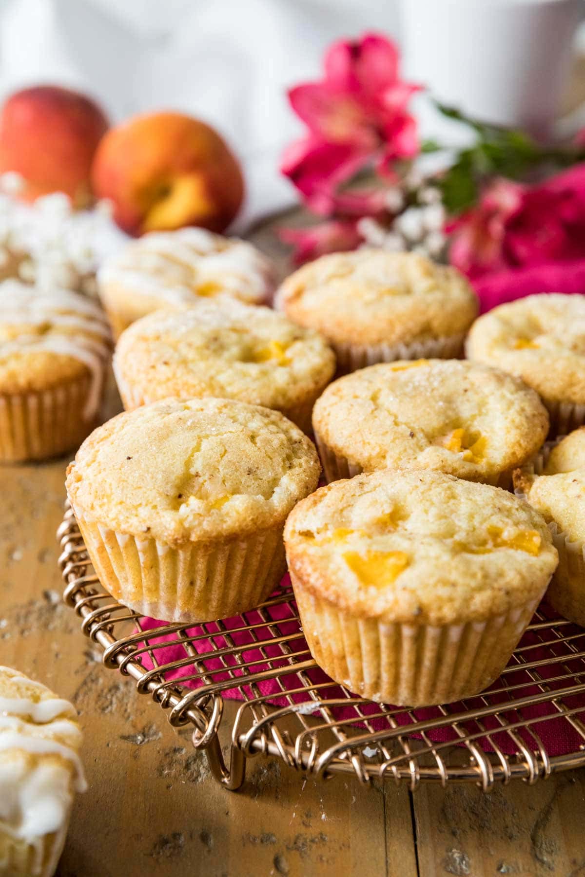 Cooling rack of muffins made with fresh peaches.