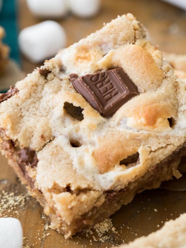 Peanut butter s'mores bar with chocolate bar pieces pressed into the top surrounded by mini marshmallows.