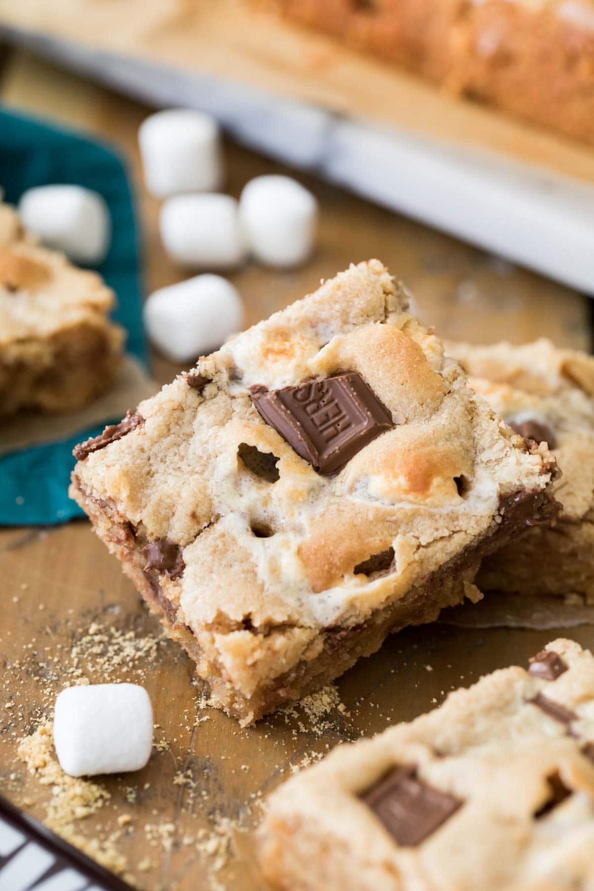 Peanut butter s'mores bar with chocolate bar pieces pressed into the top surrounded by mini marshmallows.