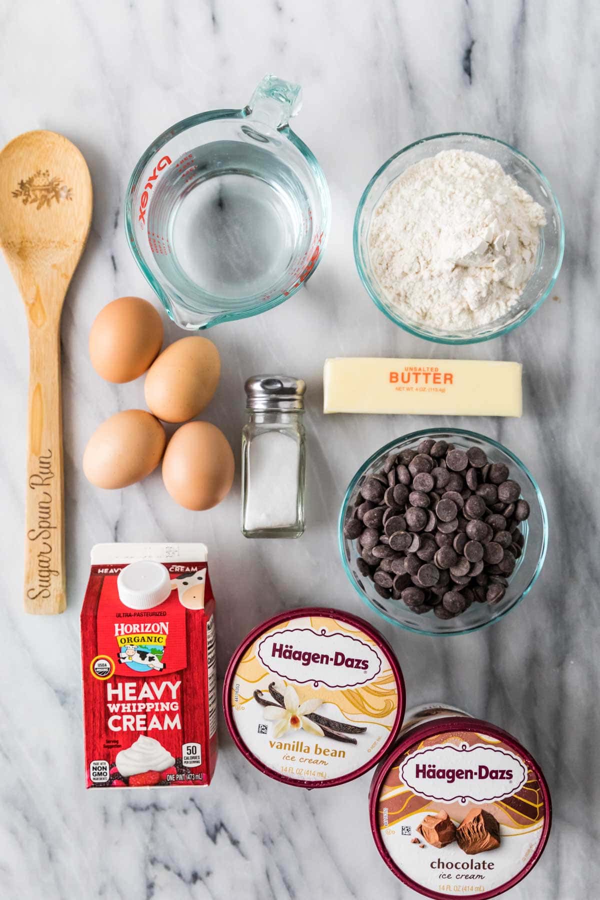 Overhead view of ingredients including eggs, ice cream, chocolate, cream, and more.