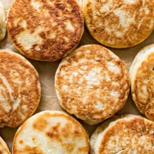 Overhead view of golden brown sourdough English muffins.