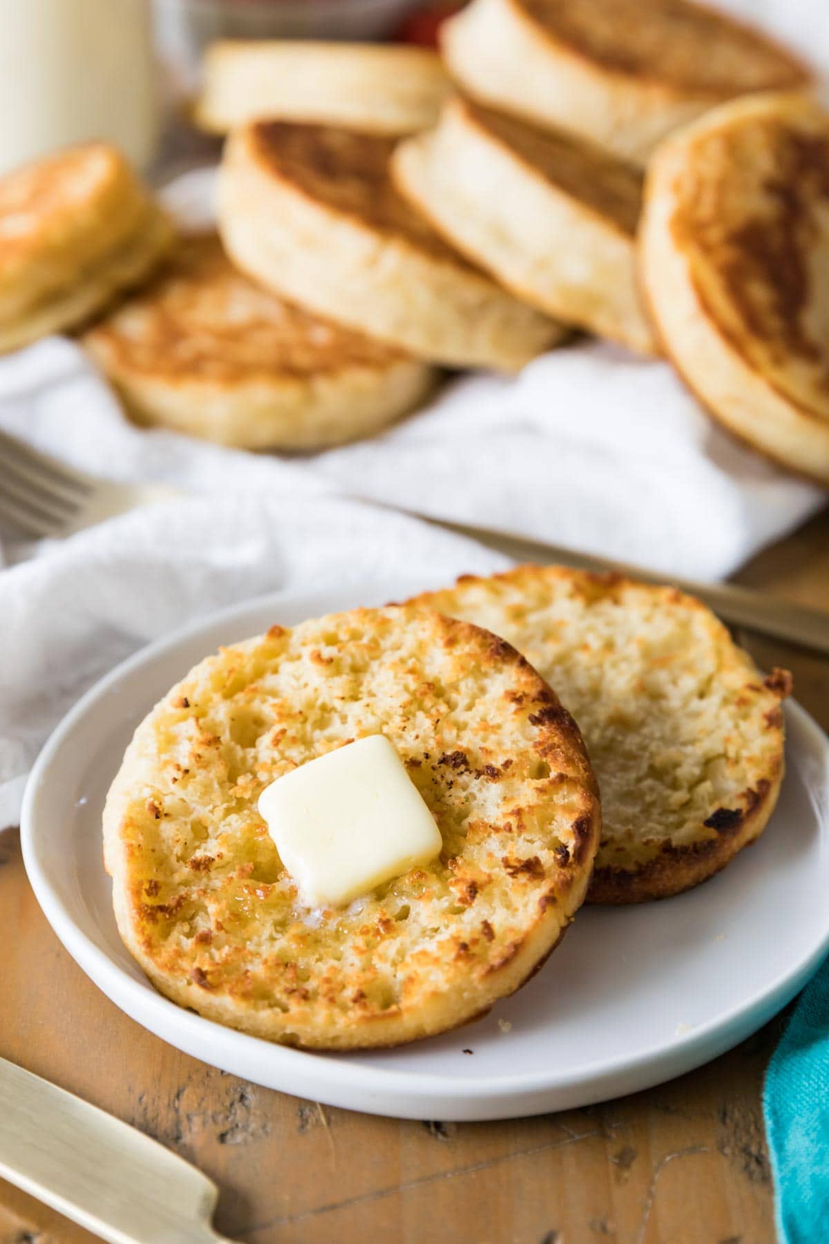 Two halves of a toasted English muffin layered and topped with a pat of butter.