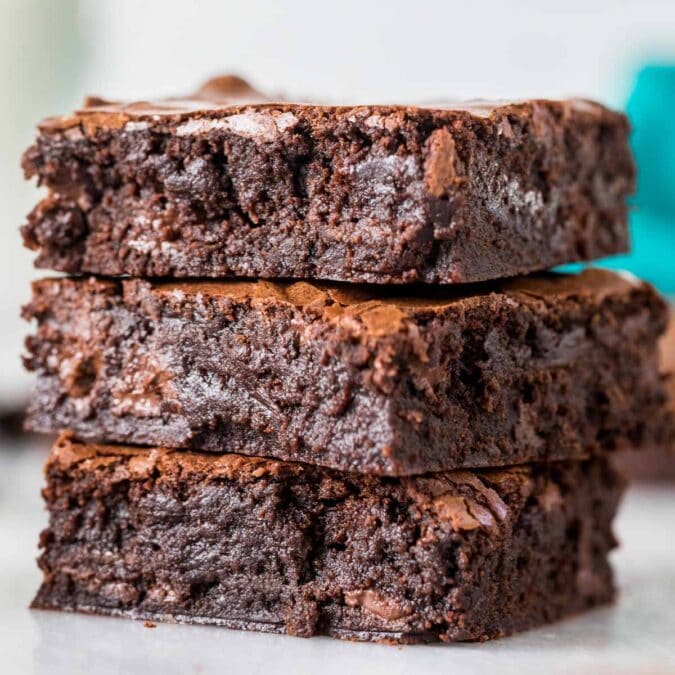 Three fudgy sourdough brownies stacked on top of each other.