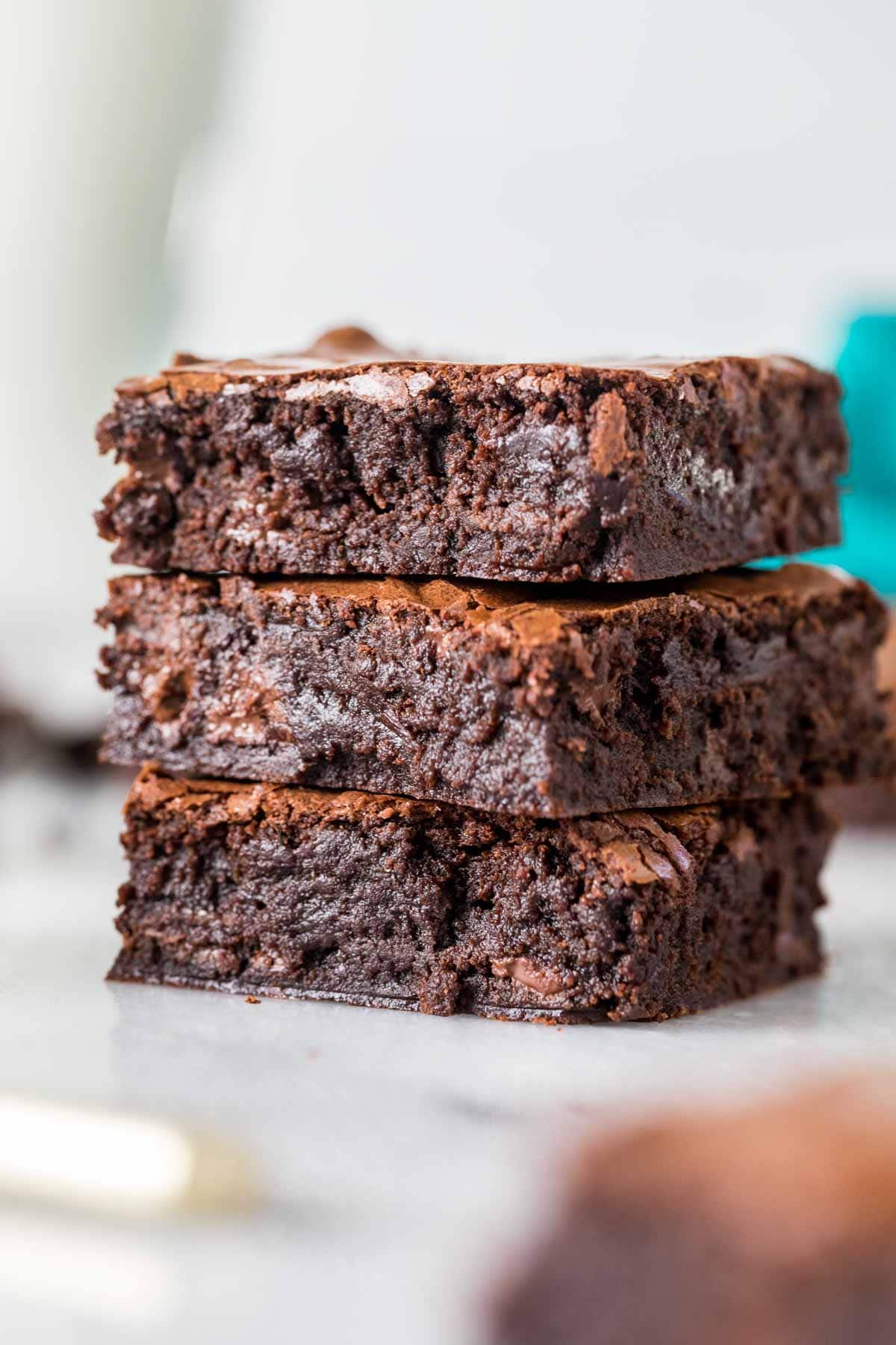 Three fudgy sourdough brownies stacked on top of each other.