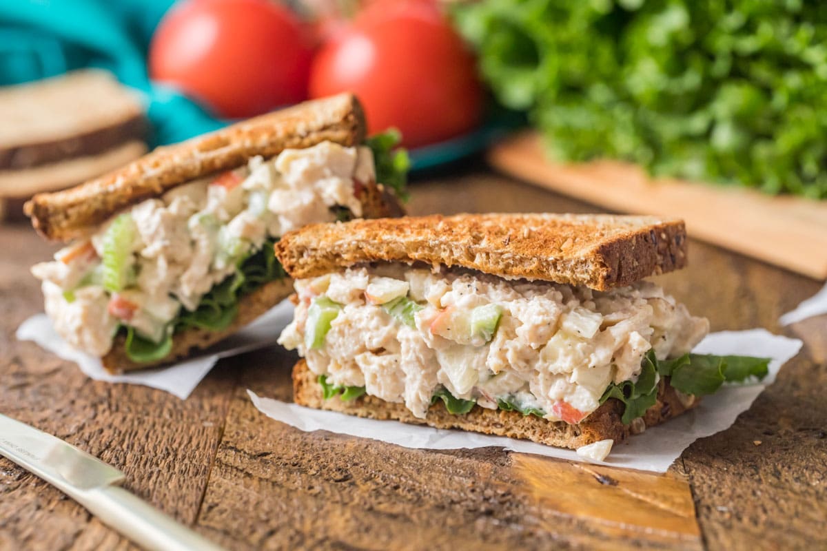 Halves of a sandwich made with diced chicken, mayo, apples, and more.
