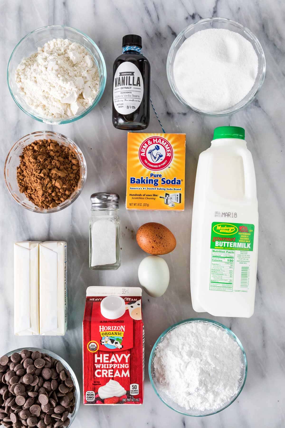 Overhead view of ingredients including cocoa powder, buttermilk, heavy cream, and more.