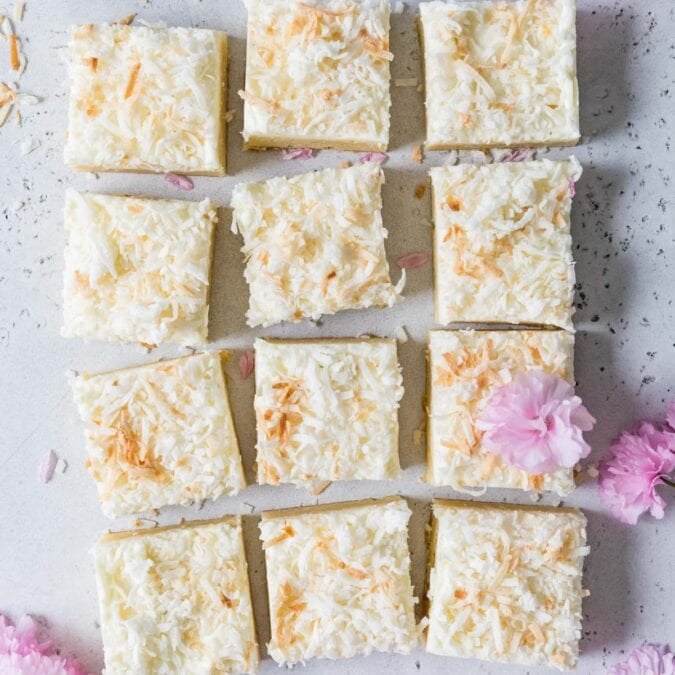 Overhead view of frosted coconut cream bars topped with toasted coconut.