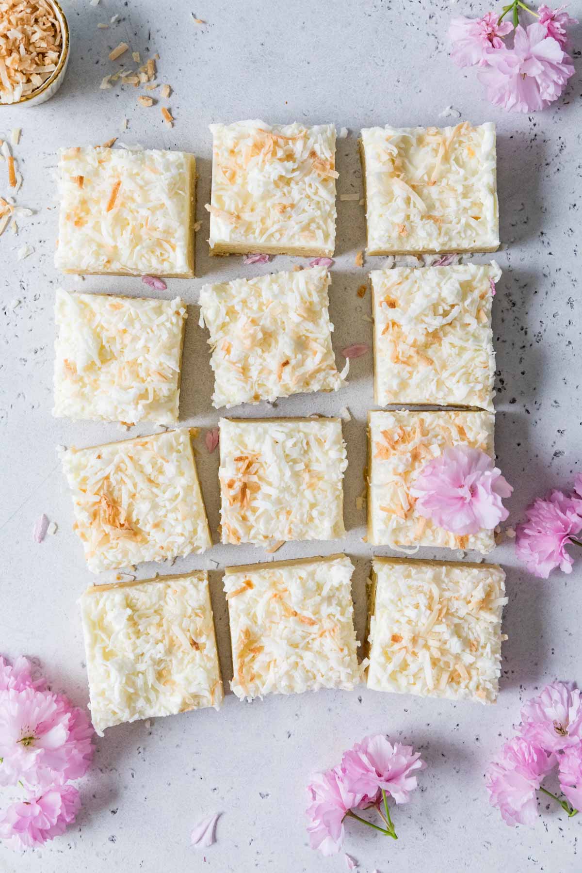 Overhead view of frosted coconut cream bars topped with toasted coconut.