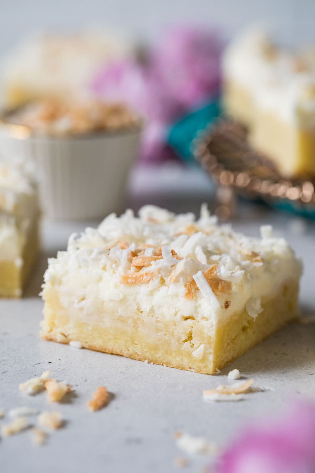 Coconut cookie bar topped with frosting and toasted coconut.