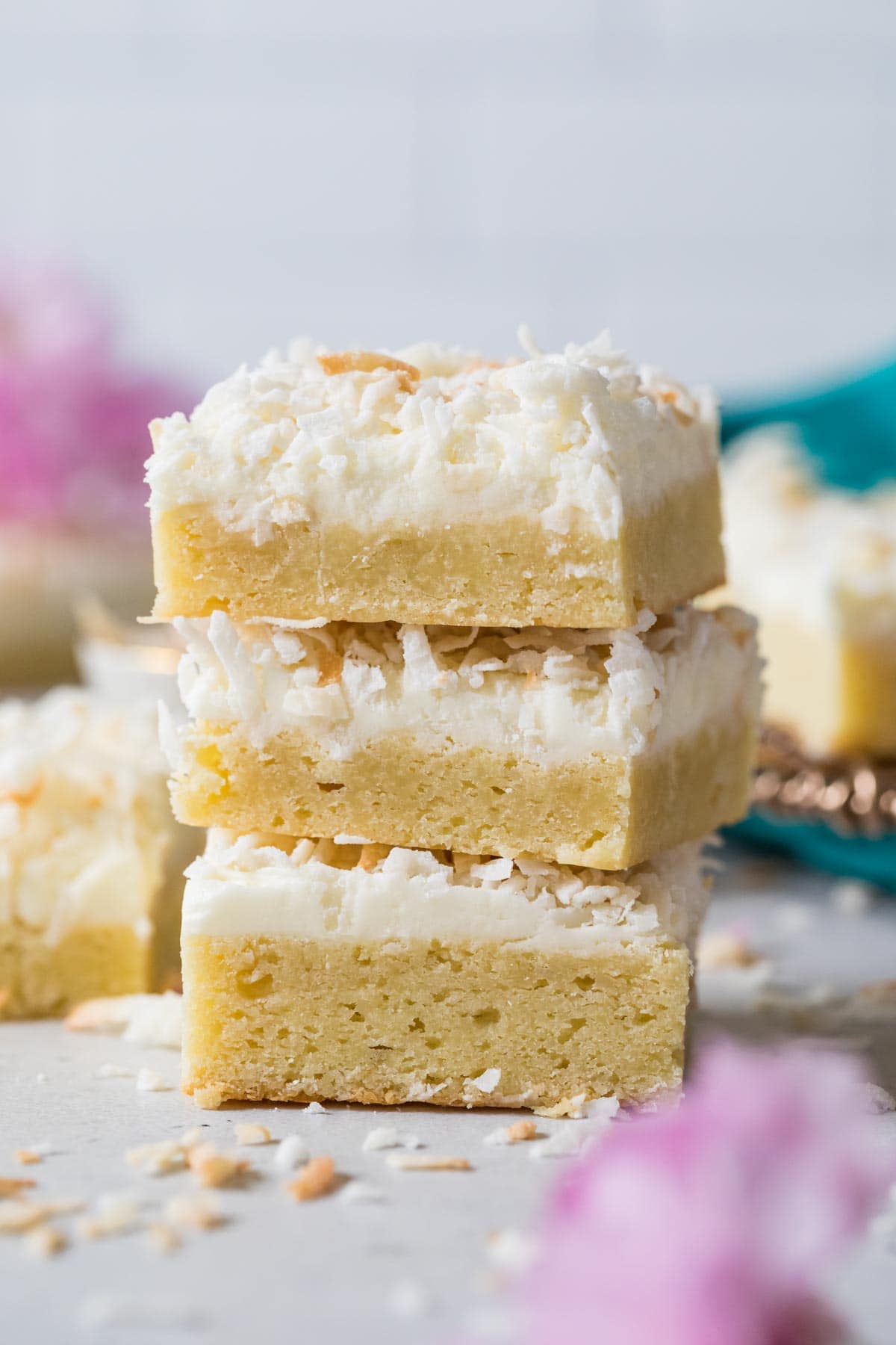 Three coconut cream bars stacked on top of each other.