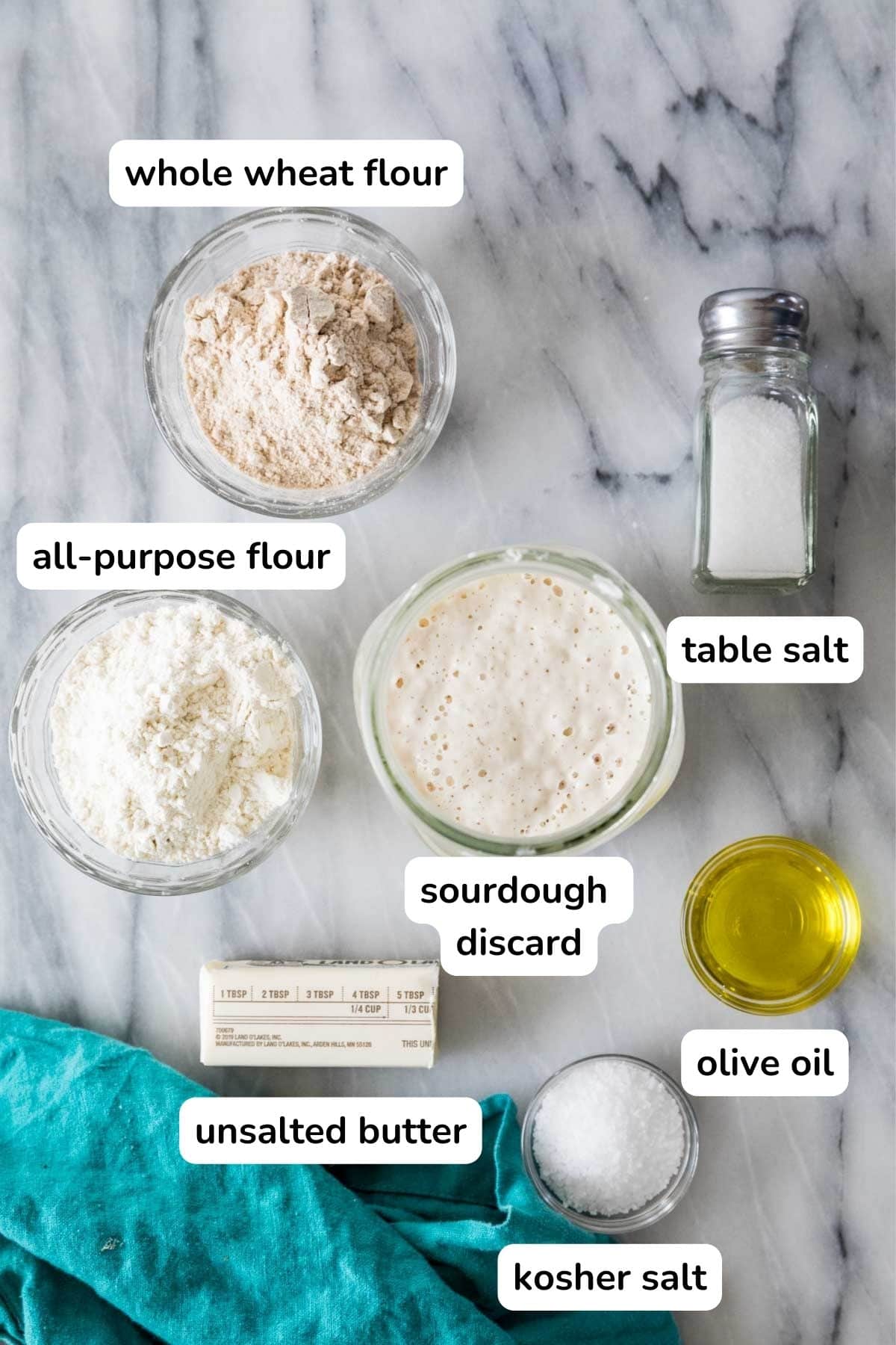Overhead view of labeled ingredients including sourdough discard, whole wheat flour, olive oil, and more.