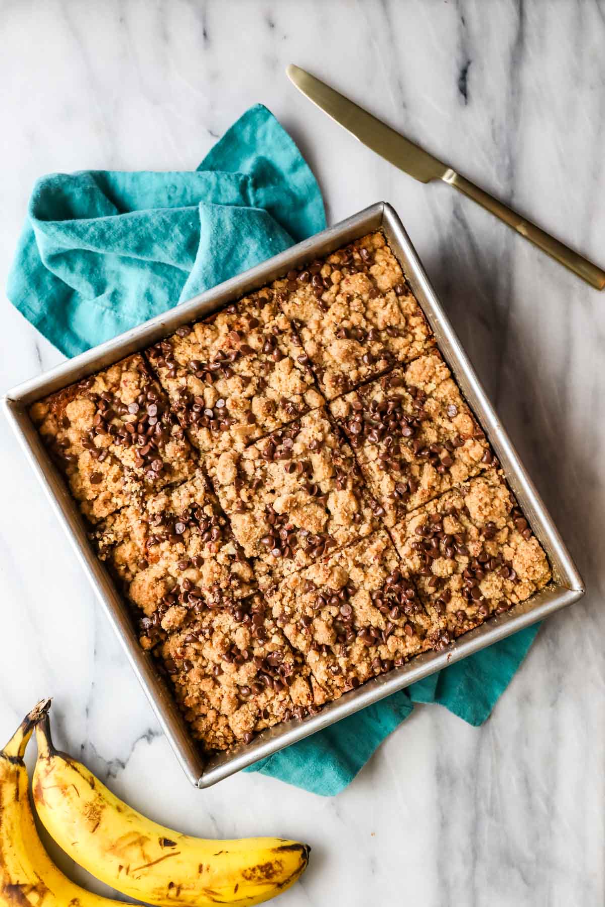 Overhead view of a square cake pan of coffee cake topped with mini chocolate chips.