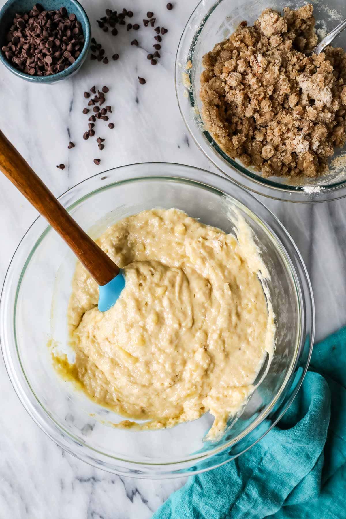 Overhead view of batter in a bowl beside a bowl of streusel.