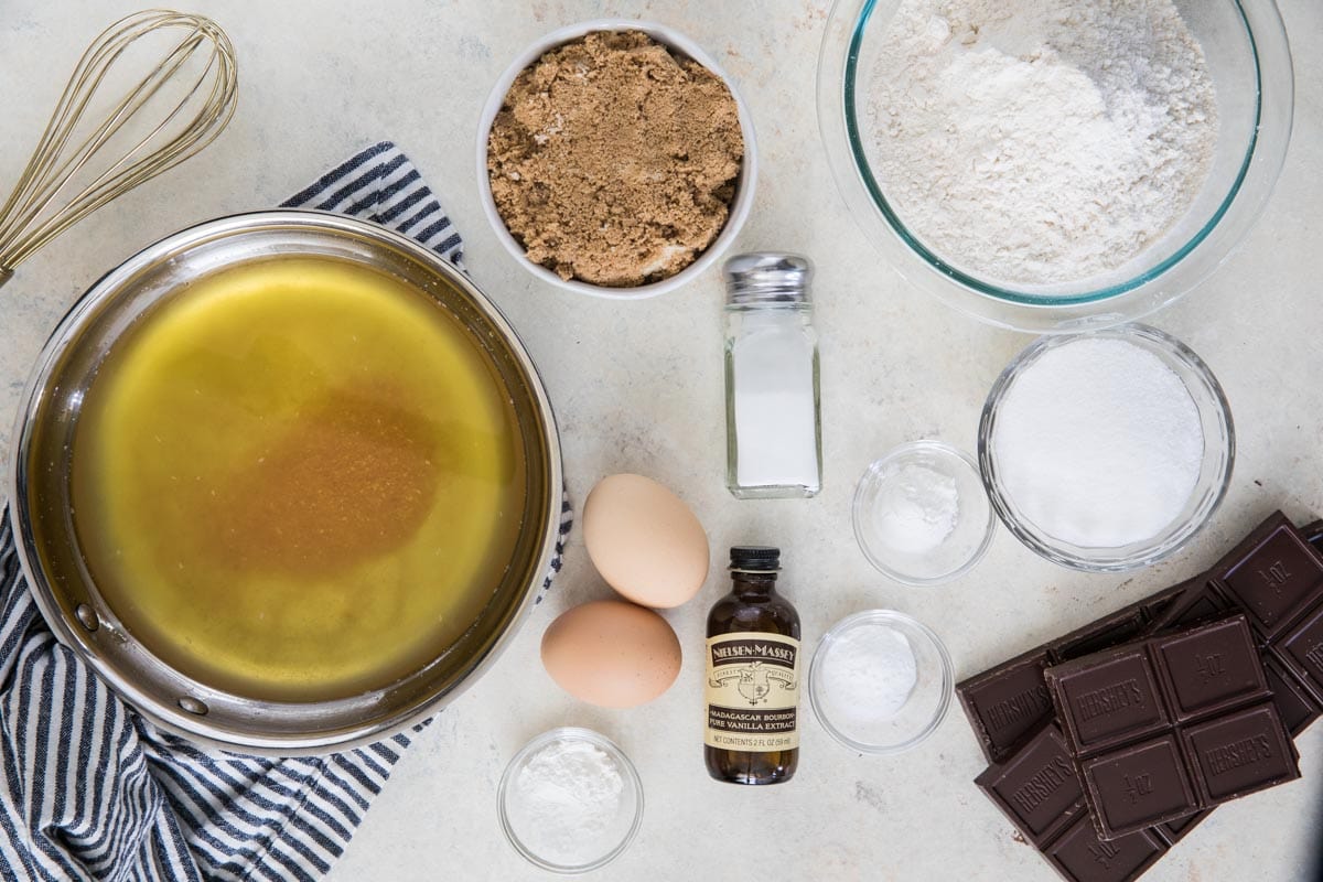 Overhead view of ingredients including brown butter, brown sugar, eggs, chocolate, and more.