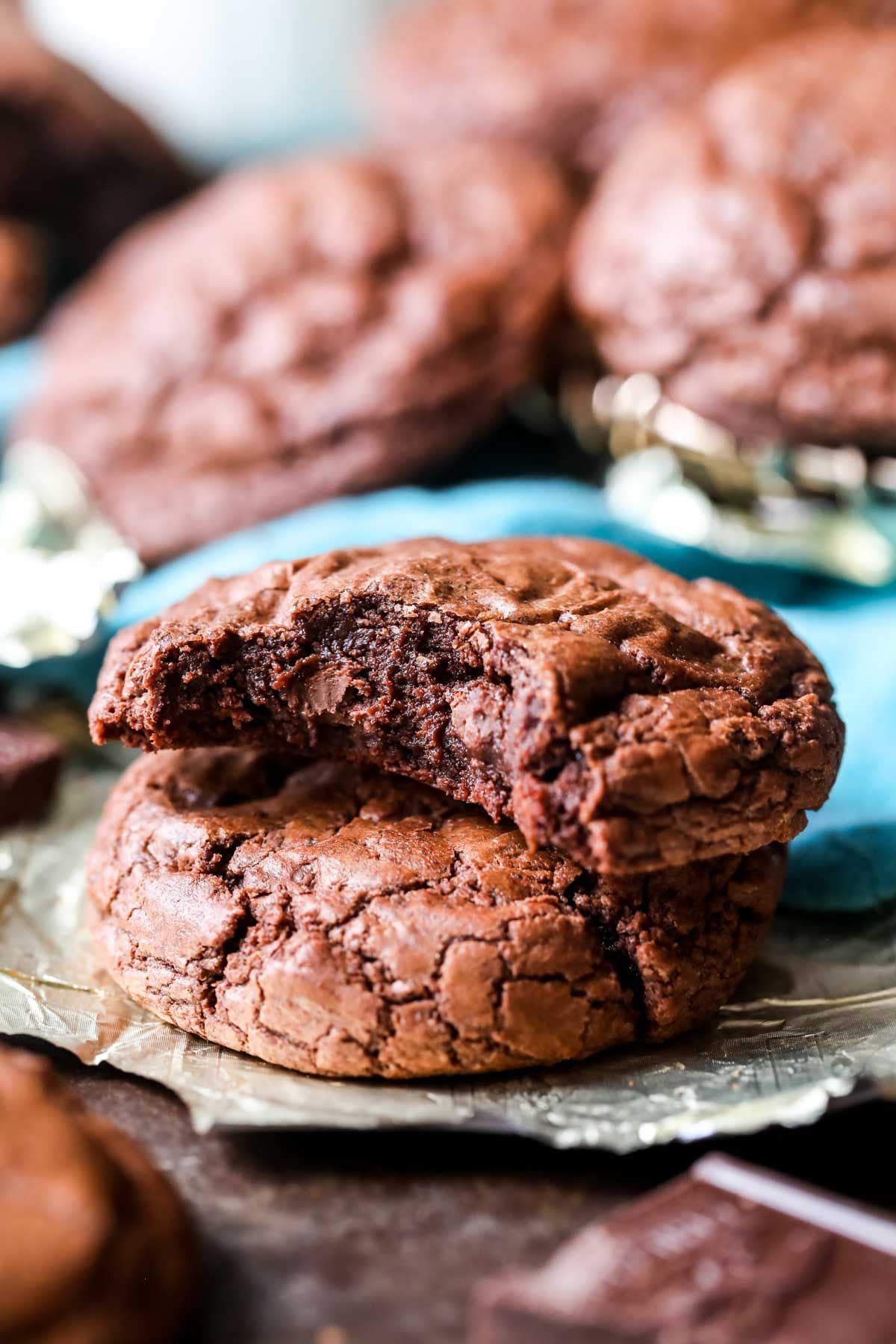 Two brownie cookies stacked on top of each other with the top cookie missing a bite.