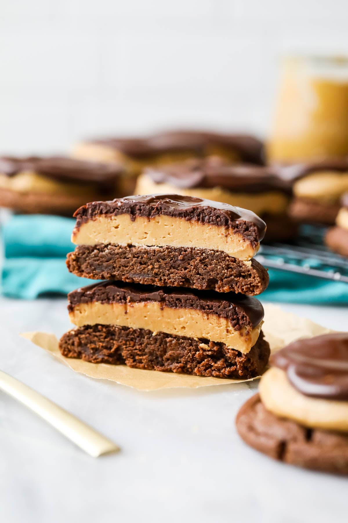 Two halves of a buckeye cookie stacked on top of each other to show layers of chocolate cookie, peanut butter, and chocolate.