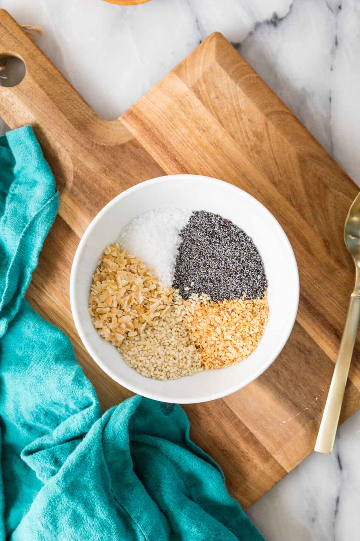 Overhead view of salt, spices, and seeds in a bowl before mixing.