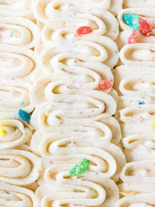 Piped ribbons of fruity pebbles frosting with fruity pebbles scattered on top.