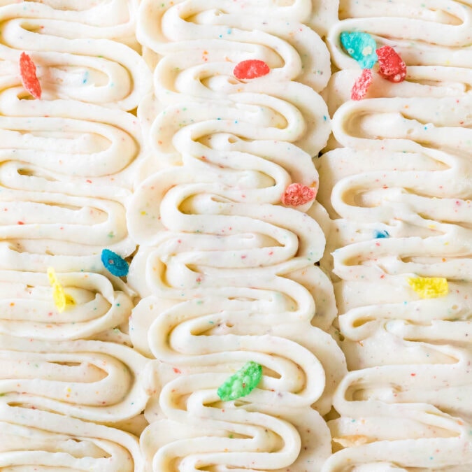 Piped ribbons of fruity pebbles frosting with fruity pebbles scattered on top.