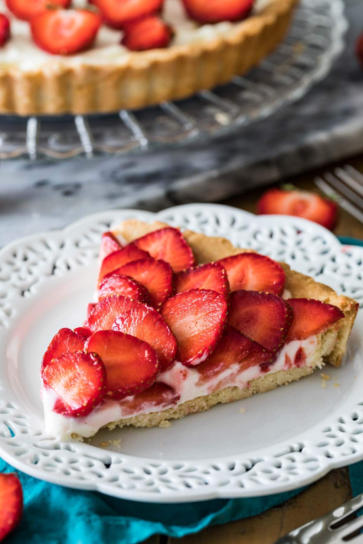 Slice of strawberry tart on a white plate.