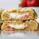 Cross section of two strawberry cheesecake cookies stacked on top of each other.