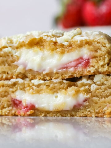 Cross section of two strawberry cheesecake cookies stacked on top of each other.
