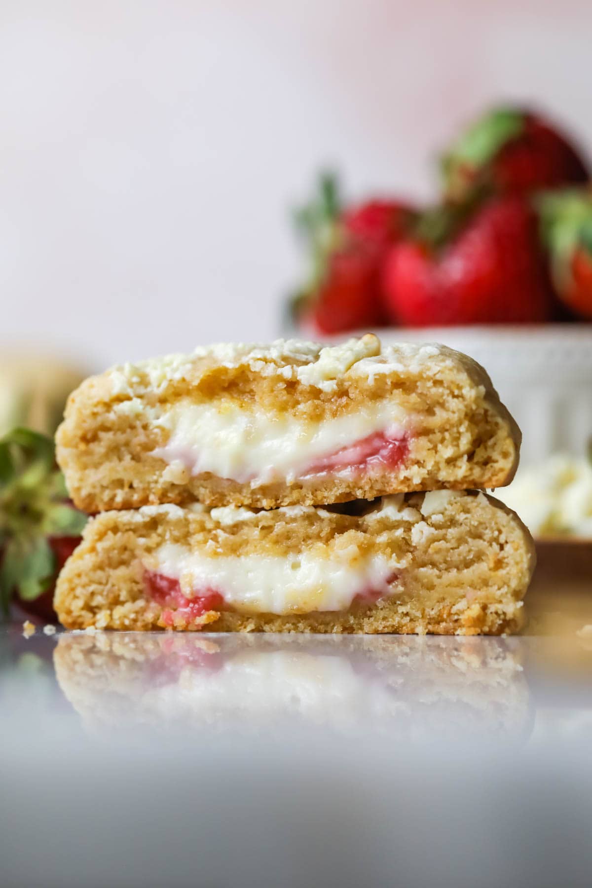 Cross section of two strawberry cheesecake cookies stacked on top of each other.