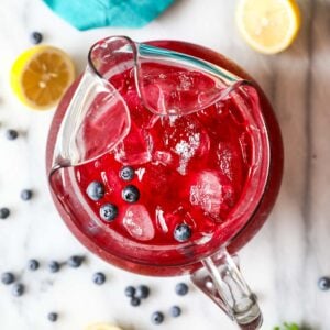 Overhead view of a pitcher of blueberry lemonade.