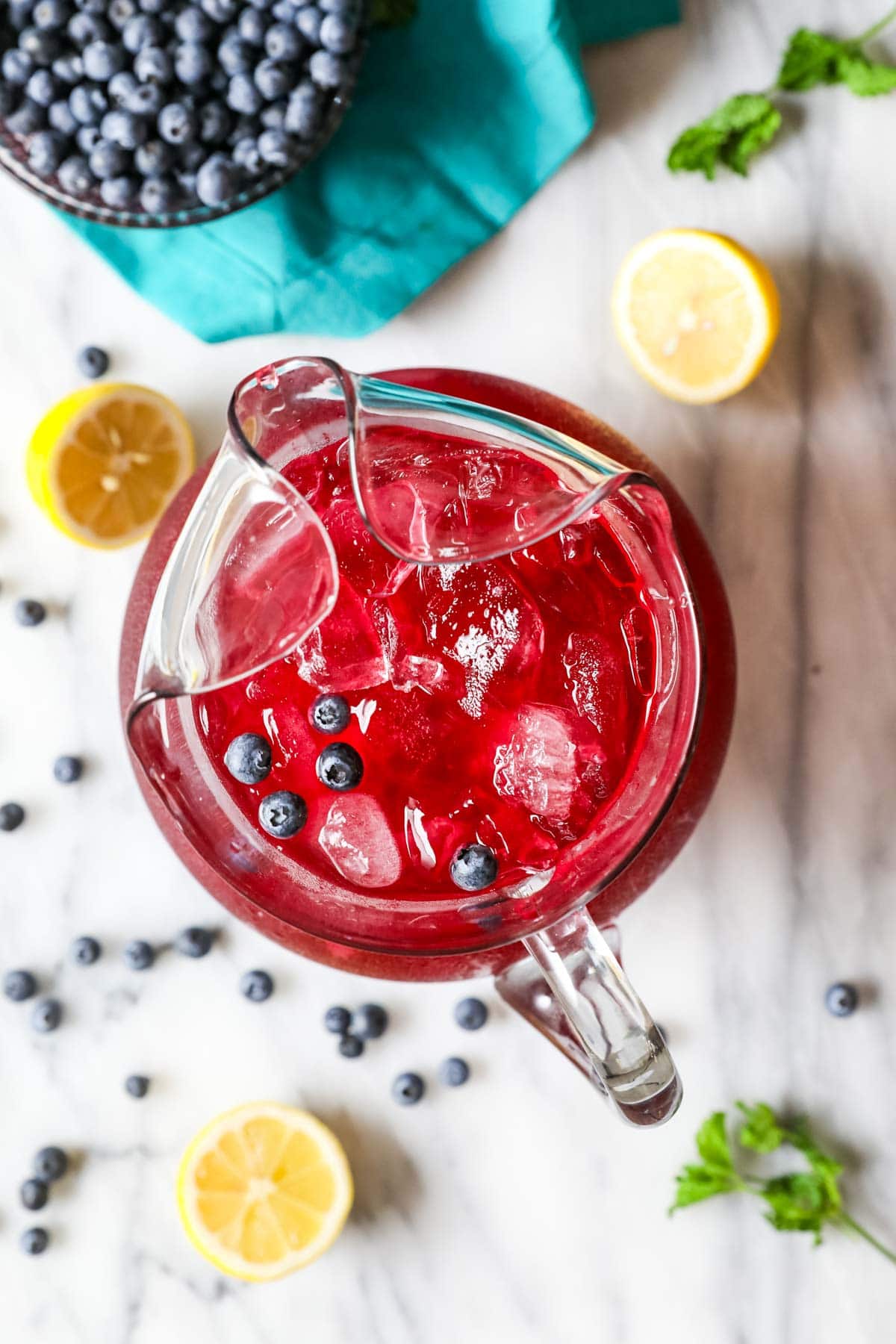 Overhead view of a pitcher of blueberry lemonade.