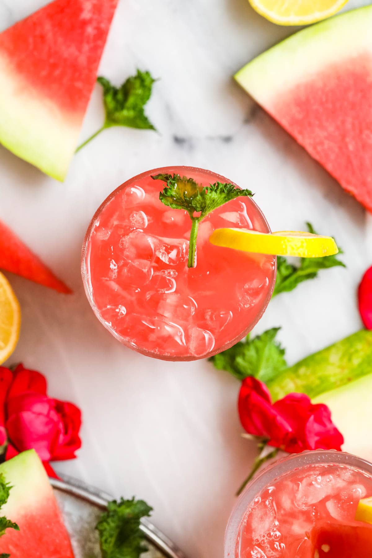 Overhead view of a glass of watermelon lemonade surrounded by watermelon slices.