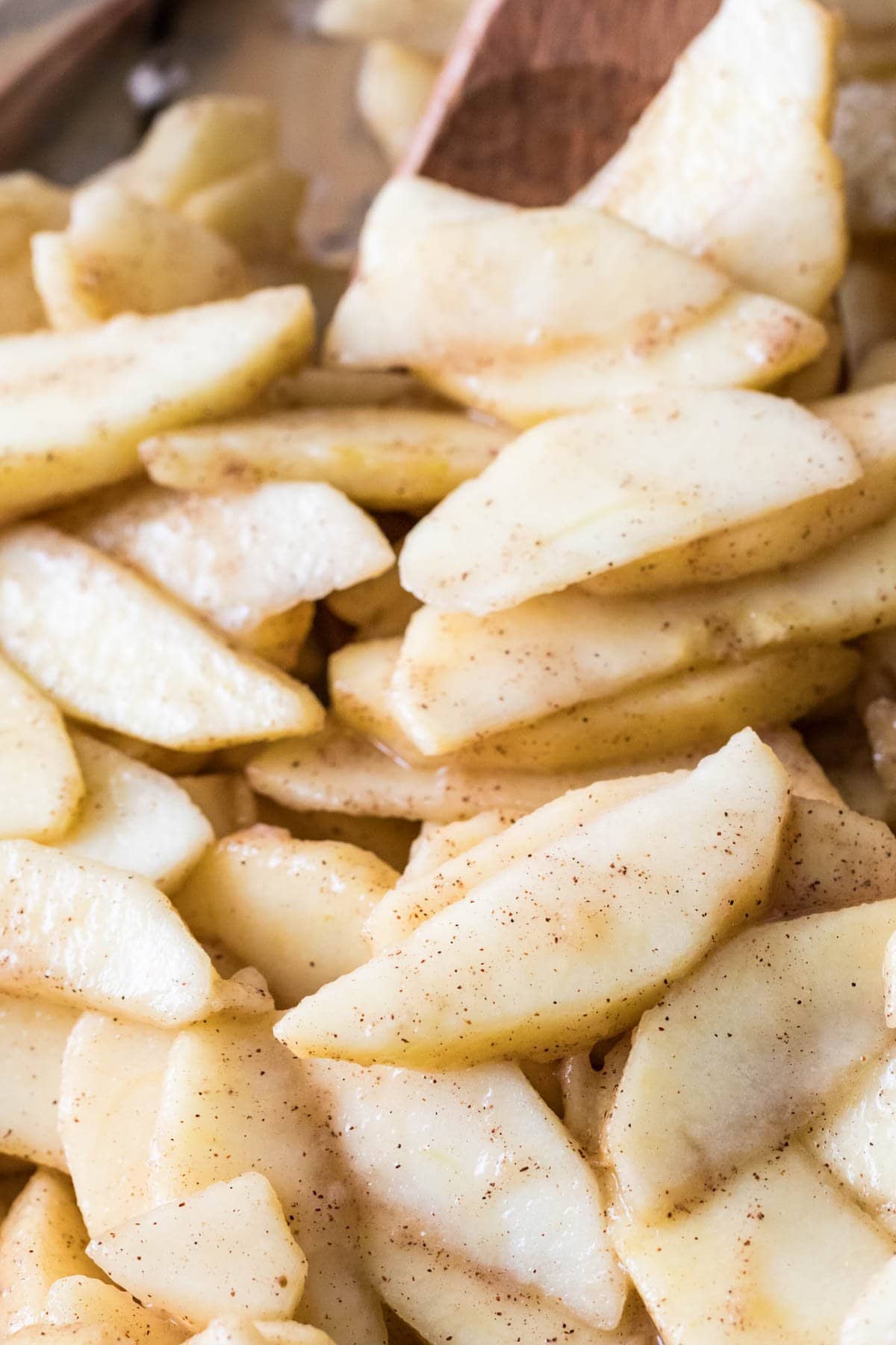 Close-up view of apple slices tossed in sugar, lemon juice and cinnamon.