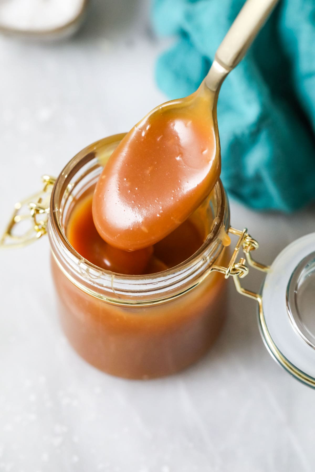 Caramel sauce being spooned out of a jar.