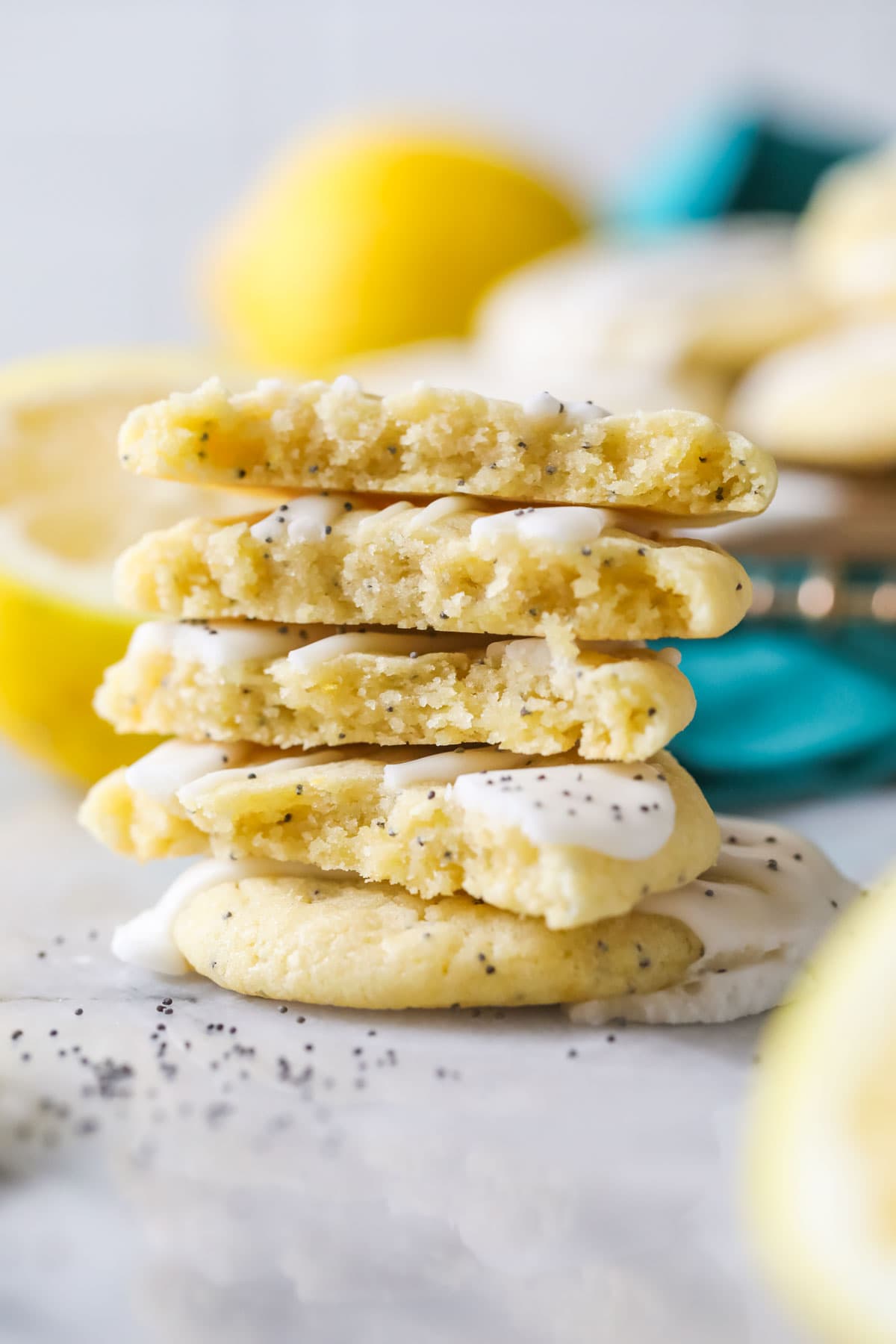 Stack of glazed lemon poppy seed cookie halves.