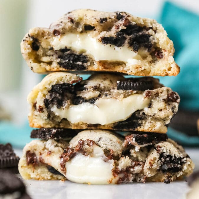 Three Oreo cheesecake cookies cut in half and stacked on top of each other.