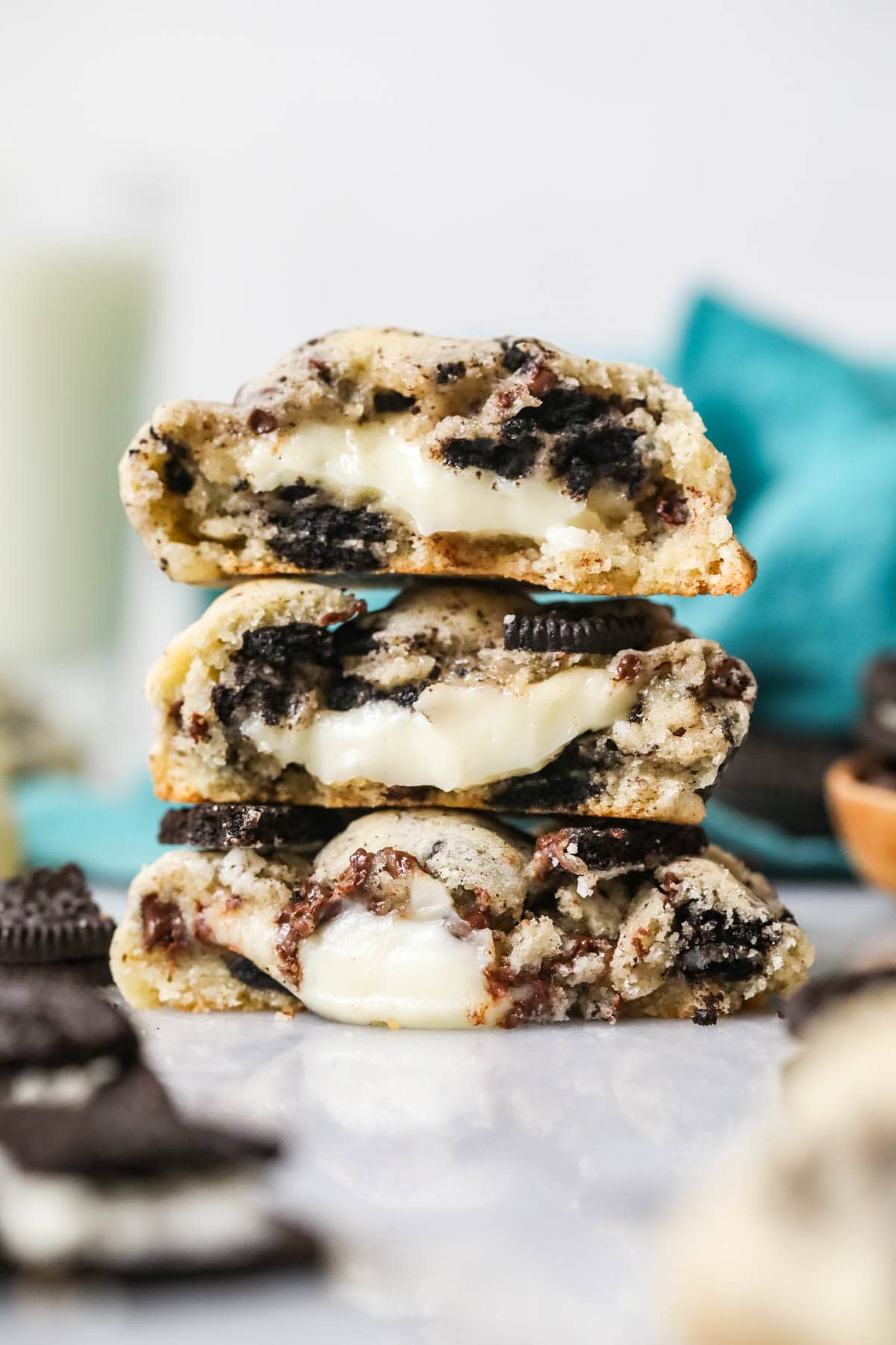 Three Oreo cheesecake cookies cut in half and stacked on top of each other.