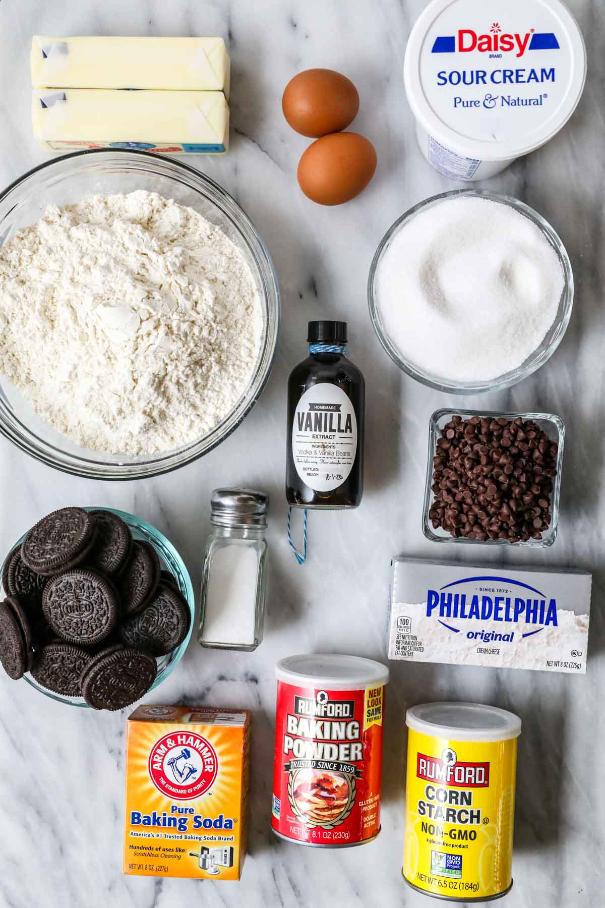 Overhead view of ingredients including cream cheese, Oreo cookies, sour cream, and more.