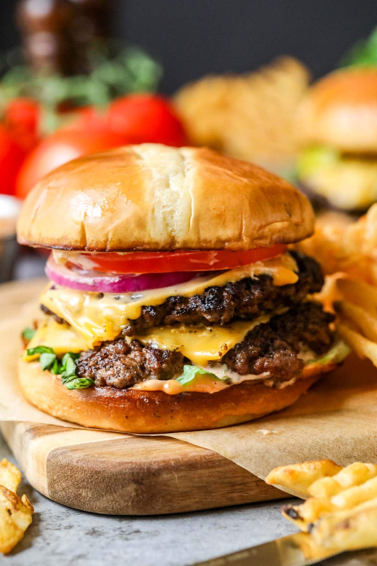 Smash burger topped with American cheese, onion, tomato, and lettuce.