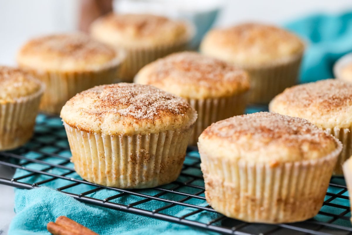 Cinnamon sugar dusted muffins on a cooling rack.