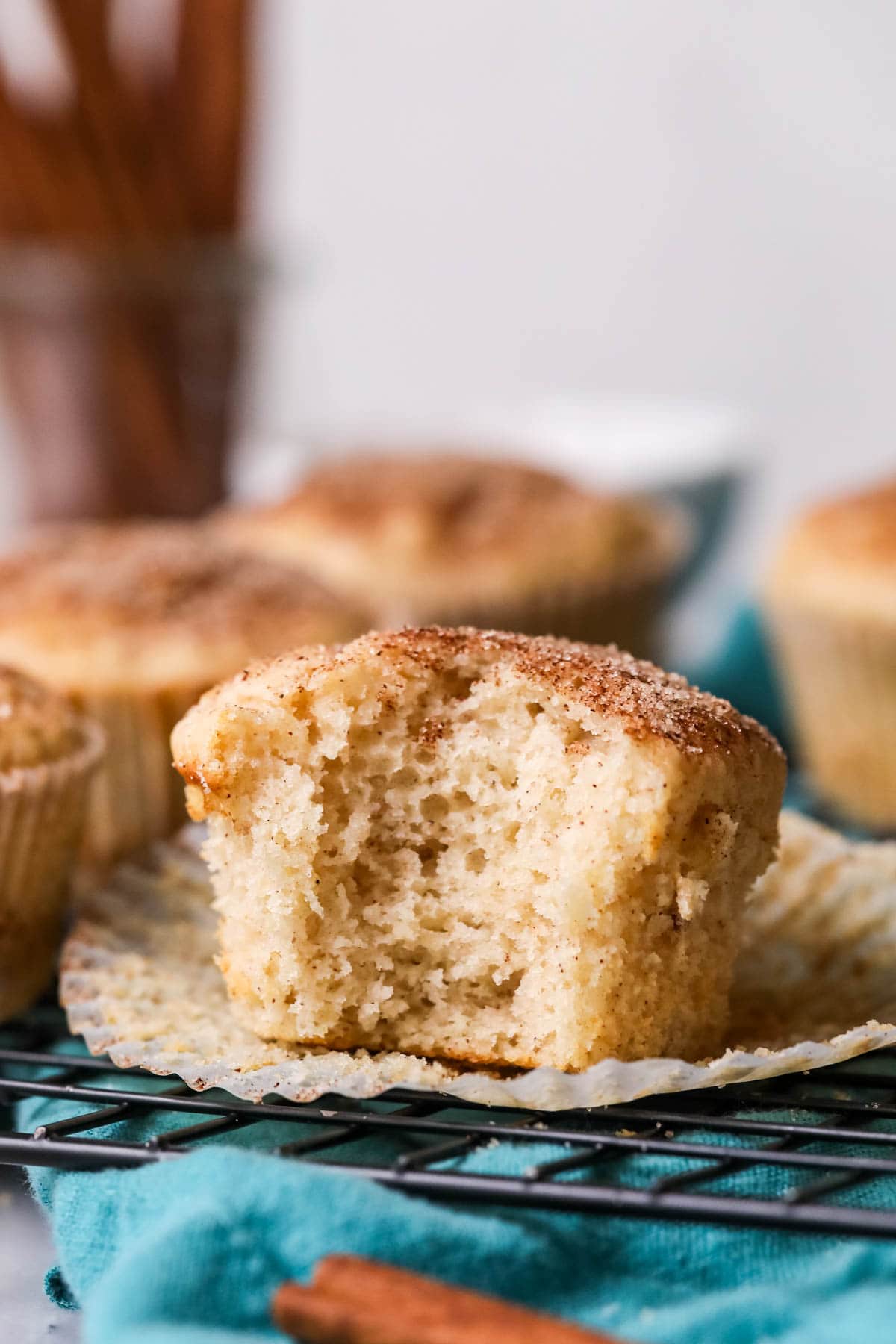 Bite missing from a muffin with a cinnamon sugar dusted top.