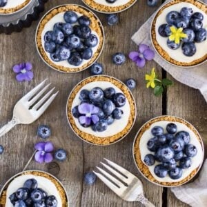 Overhead view of lemon blueberry tarts served in mason jar lids.