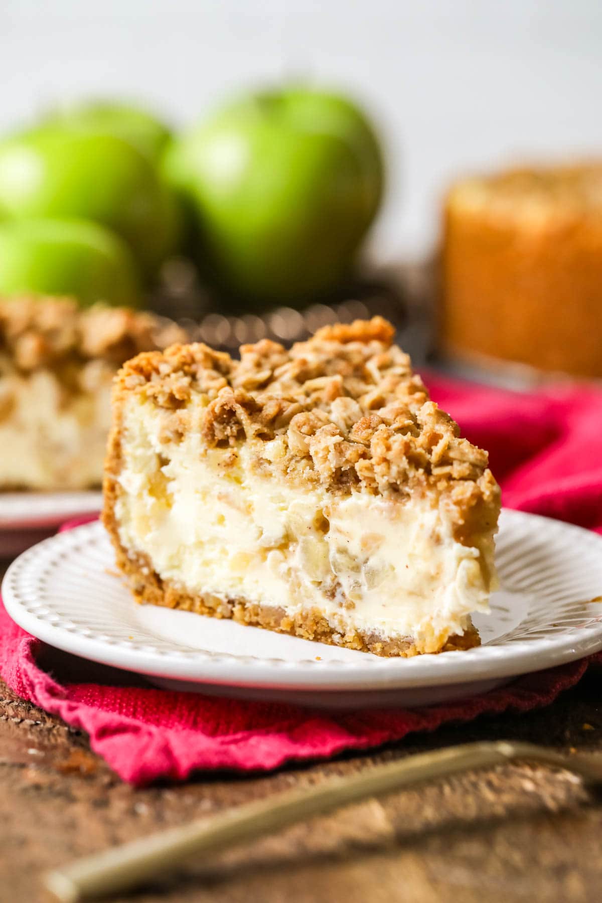 Slice of apple pie cheesecake on a plate.