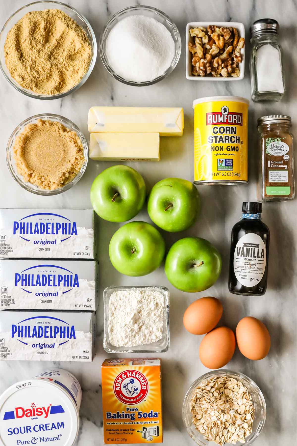 Overhead view of ingredients including apples, brown sugar, walnuts, cream cheese, and more.