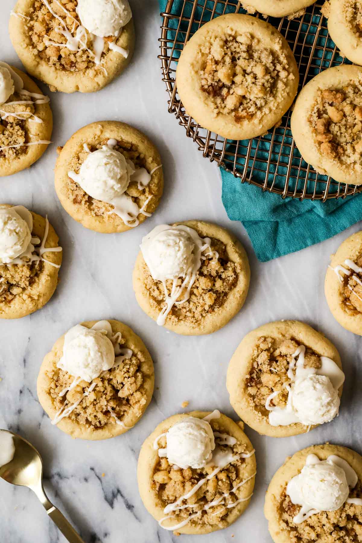 Overhead view of apple pie cookies topped with a glaze and scoop of buttercream "ice cream". 