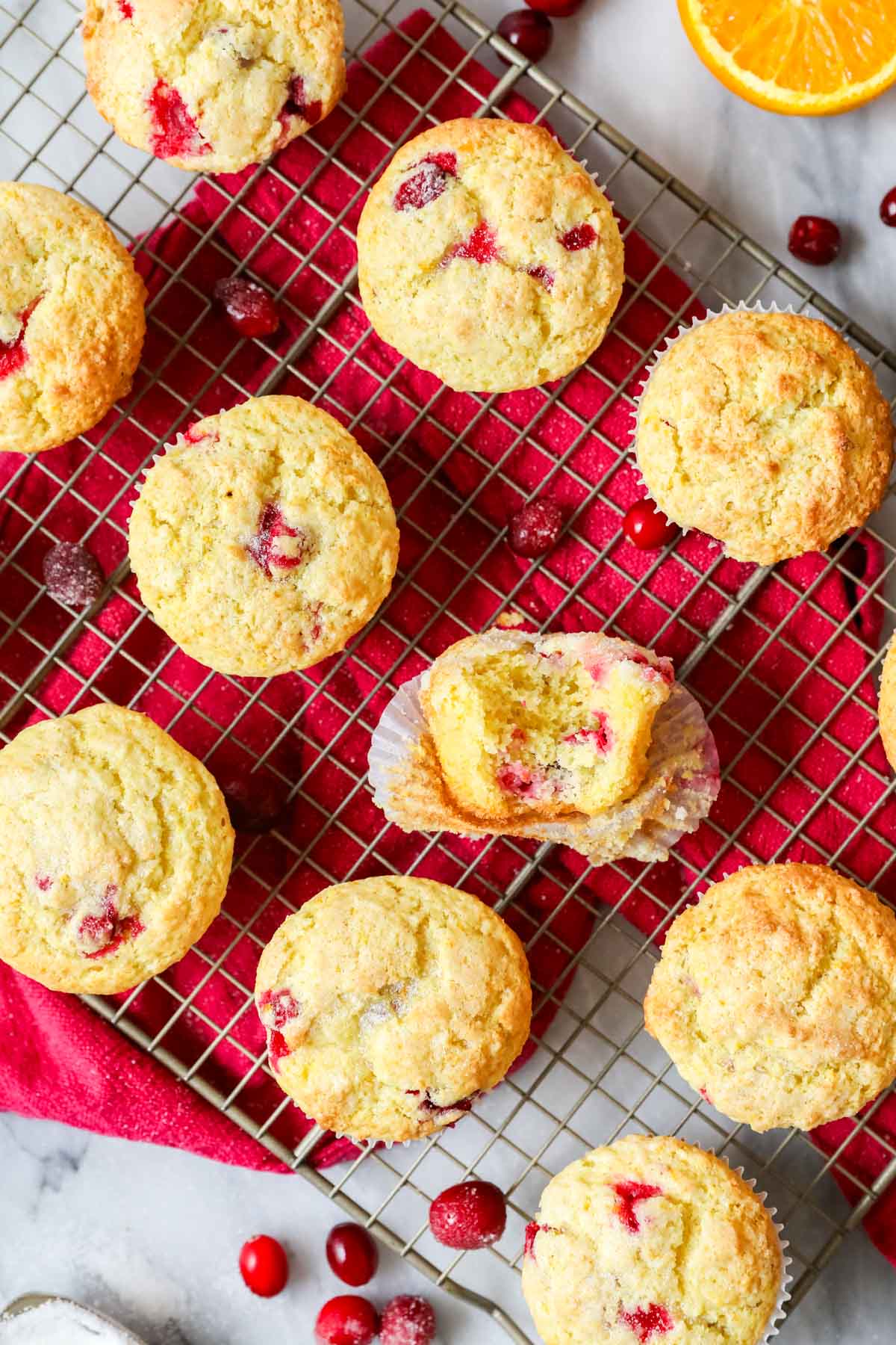 Overhead view of muffins made with cranberries and oranges on a cooling rack.