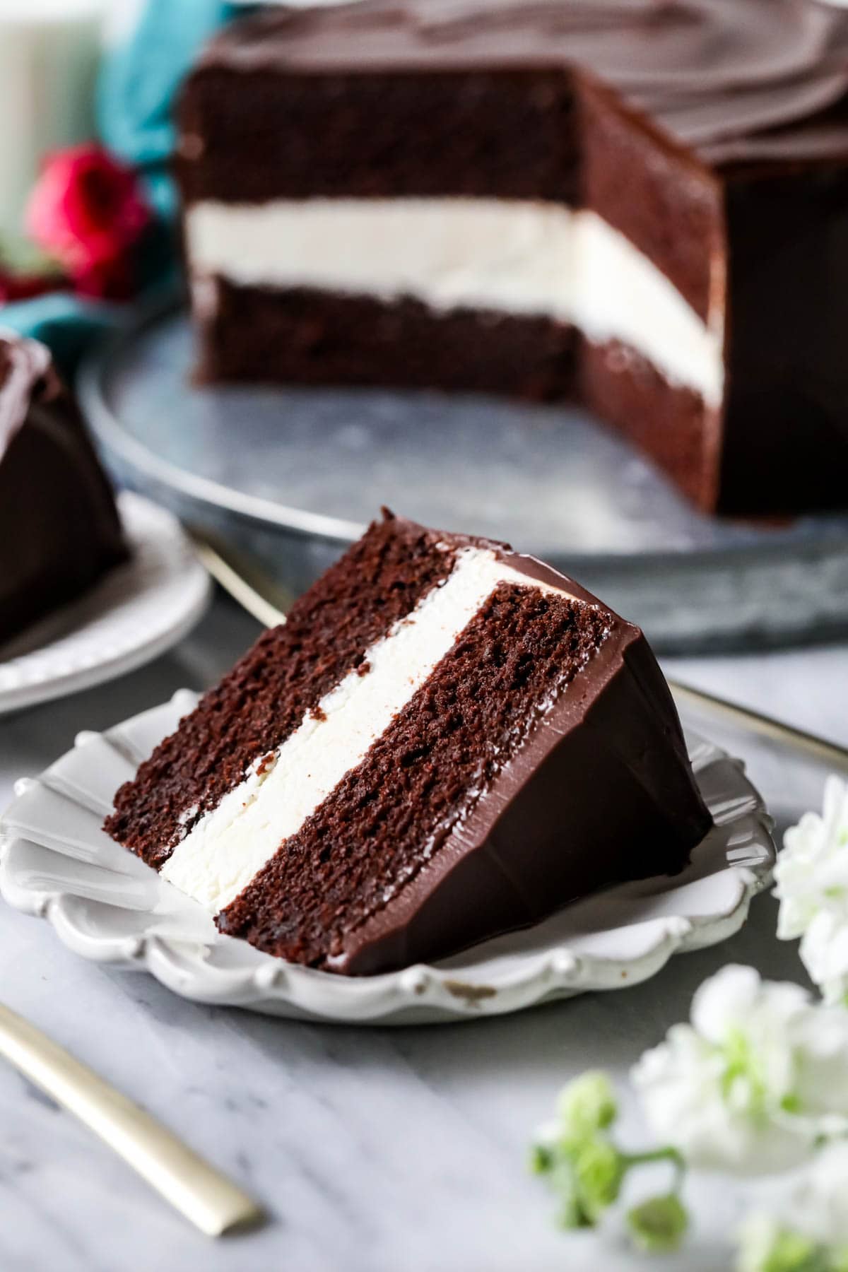 Slice of cake made with chocolate cake layers, a creamy ermine filling, and chocolate ganache topping.