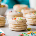 Fruity pebble macarons on a white countertop.