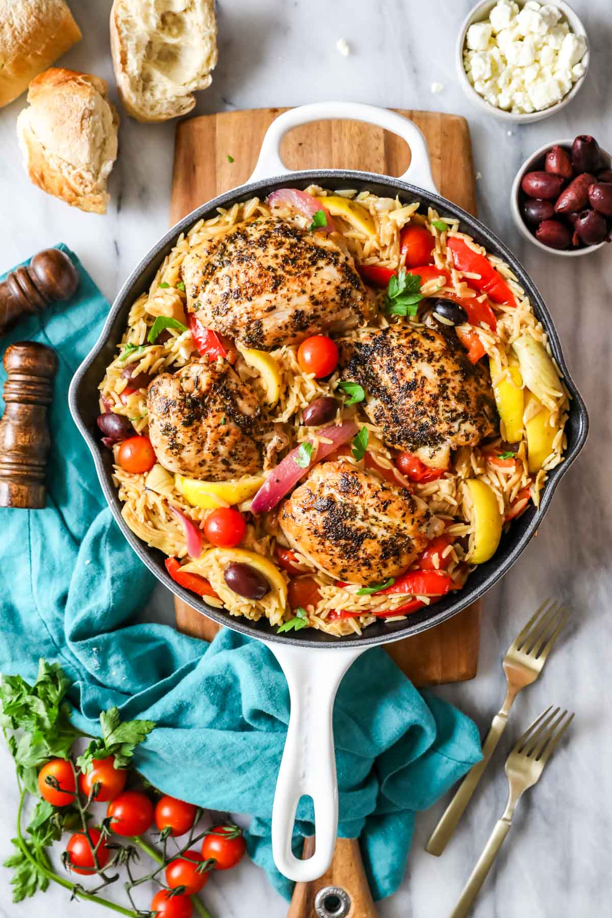 Overhead view of Greek chicken orzo in a cast iron skillet.