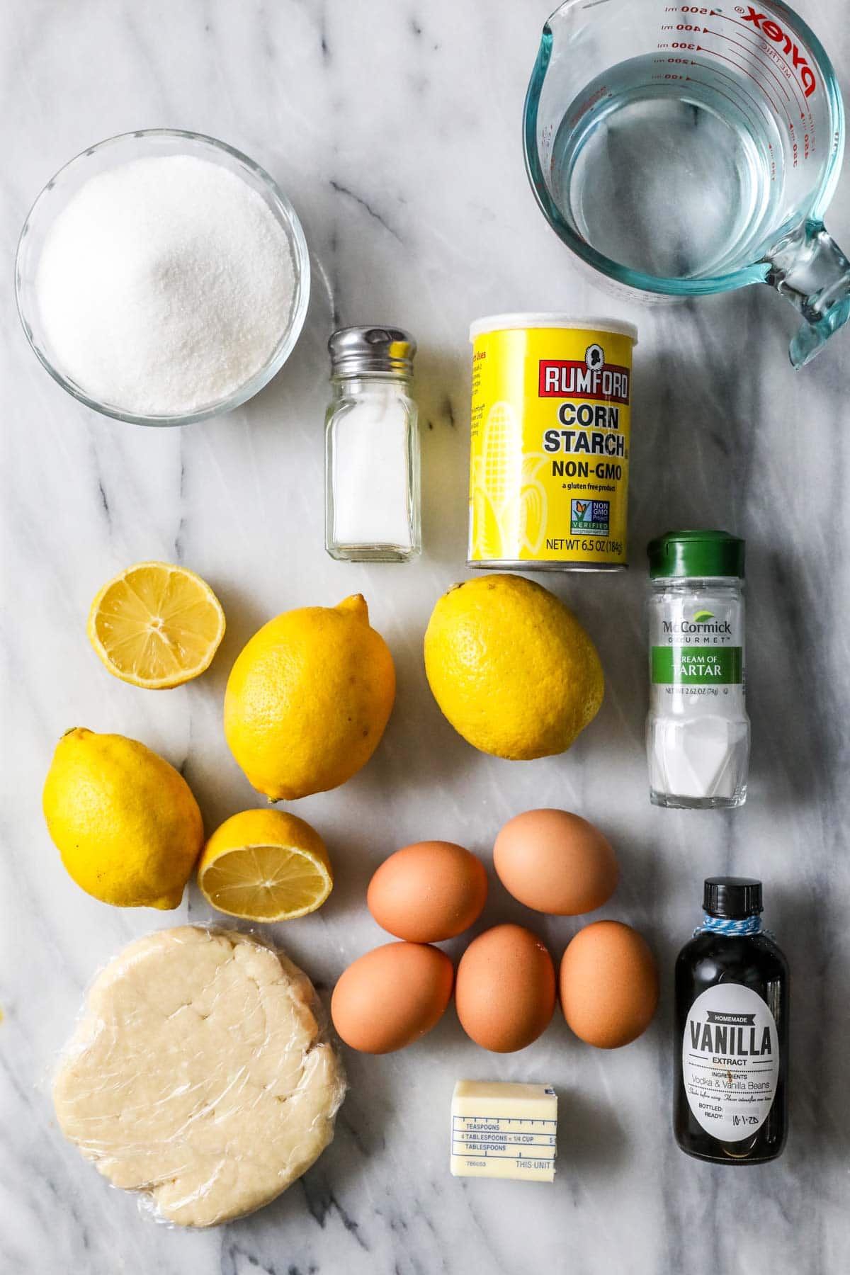 Overhead view of ingredients including lemons, eggs, pie dough, and more.
