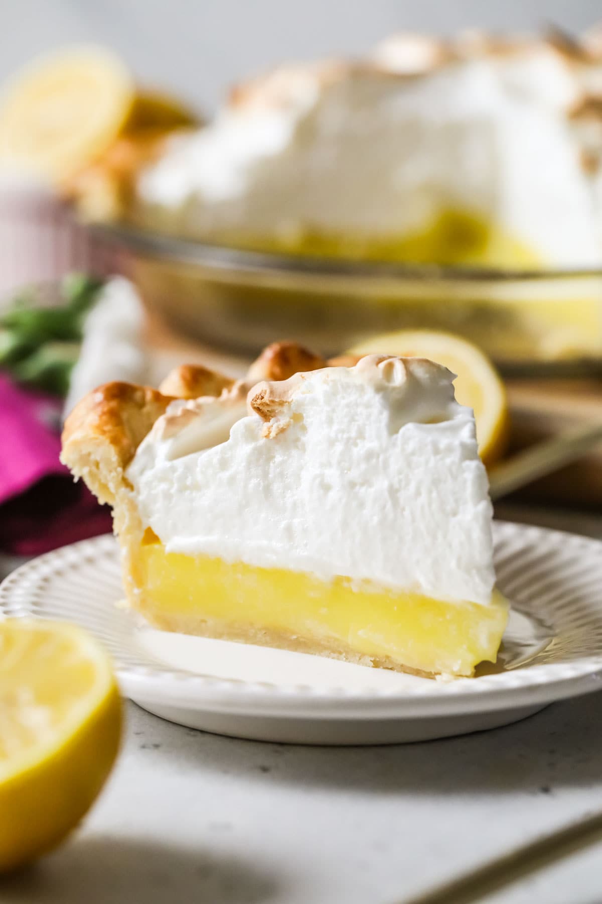 Slice of lemon meringue pie on a plate.